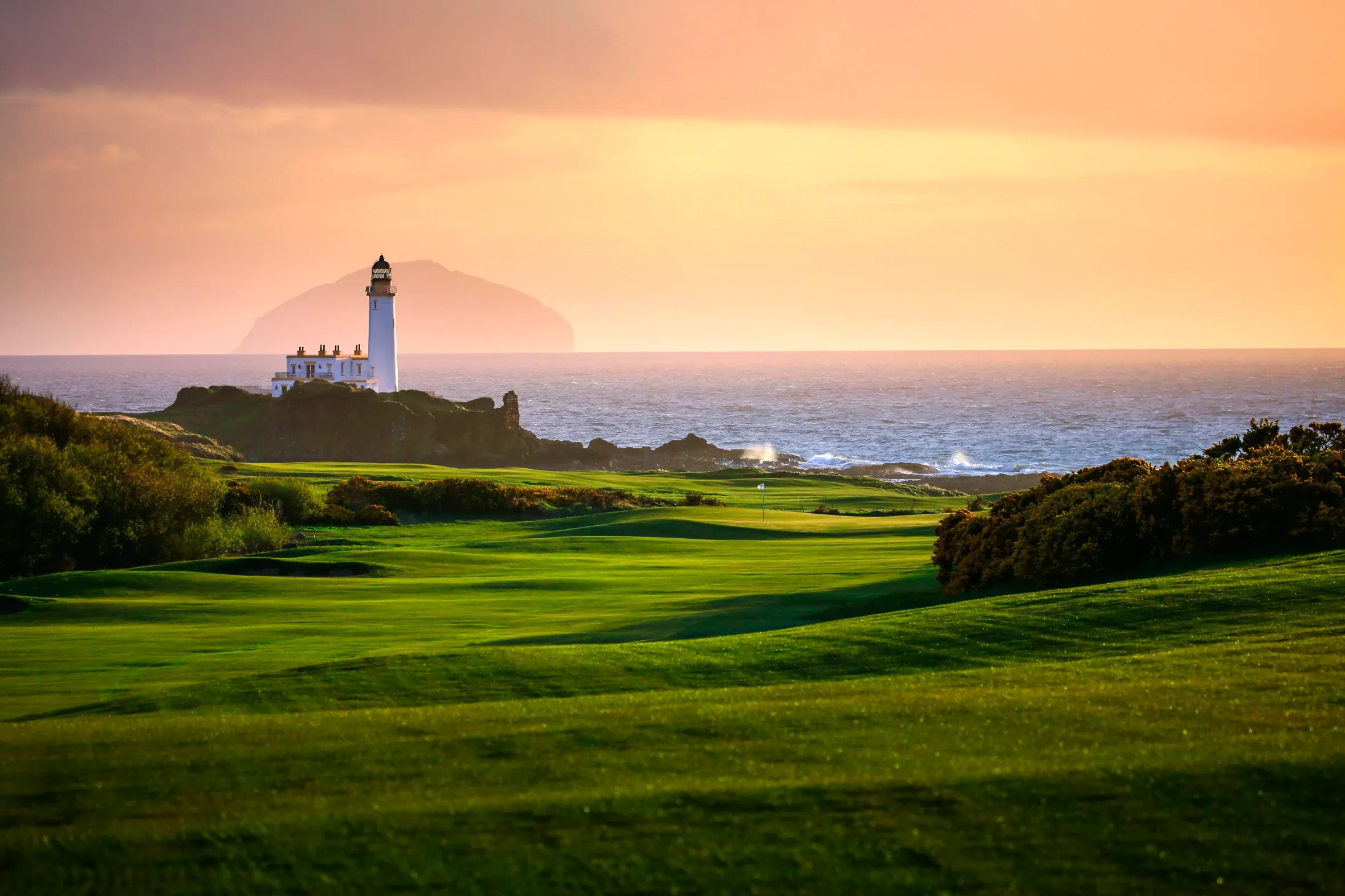 Trump Turnberry Lighthouse and golf course at sunset.