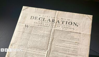 A copy of the US Declaration of Independence. The word "declaration" can be seen in capital letters on the document, which has various folds and creases.