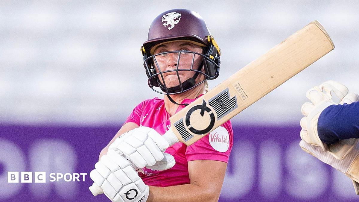 Niamh Holland in a pink shirt swipes her bat
