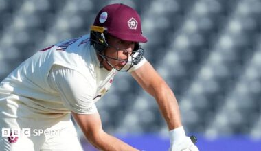 Nathan McSweeney in cricket whites and a claret Northants batting helmet defends the ball