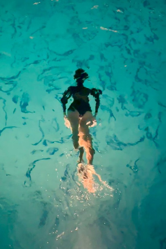 A guest swims in the Hollywood Roosevelt Hotel’s pool at night.