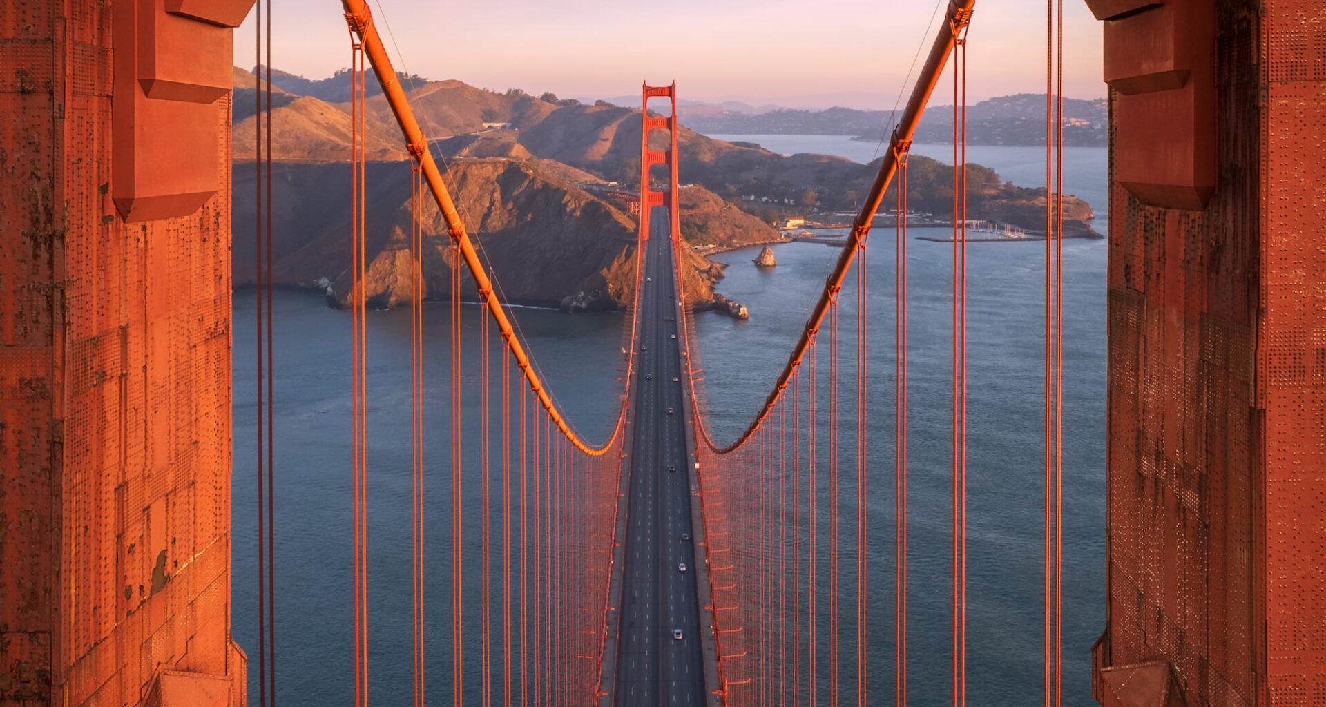 an aerial photograph of the Golden Gate Bridge in San Francisco framed through one of its tower