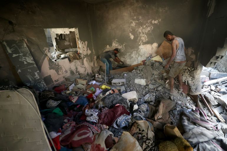 Palestinians look for their belongiongs at the site of an Israeli strike at the Bureij refugee camp in the central Gaza Strip, on July 16, 2026