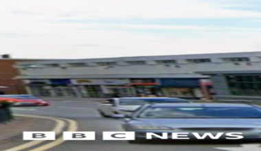 Cars drive along High Street in the town centre near the central bus station.