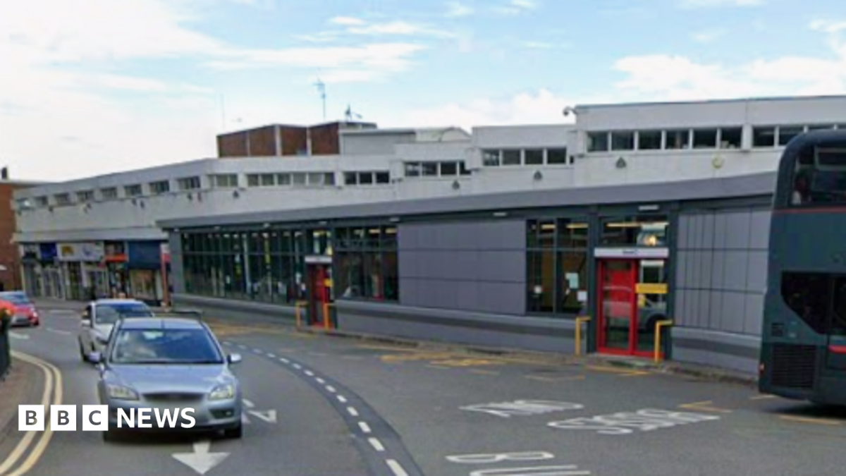 Cars drive along High Street in the town centre near the central bus station.