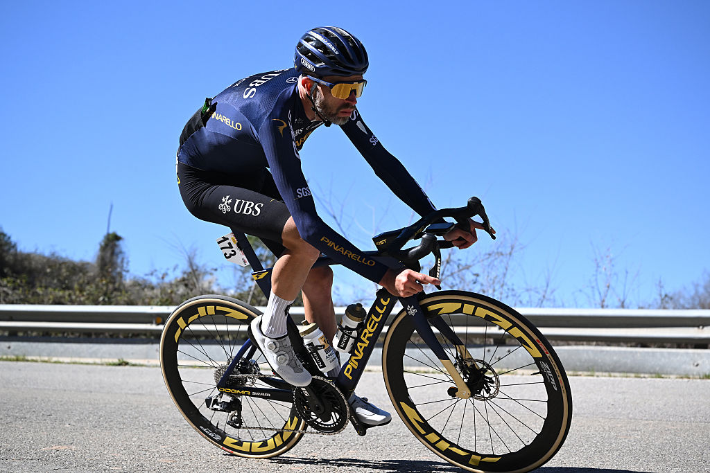 Howson riding a descent as the only rider in the photo, in front of a blue sky