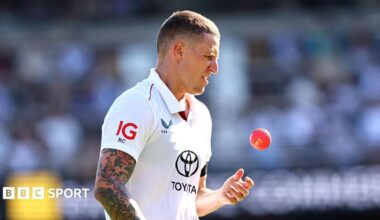 Brydon Carse playing for England in the day-night Test in Brisbane, during the day session as he throws up the pink ball