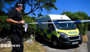 Police cars stand in the village of Haytor