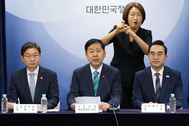 Finance Minister Koo Yun-cheol, center, speaks during a press briefing at Government Complex Seoul, Tuesday, announcing the  economic growth strategy for the second half of the year. From left are Financial Services Commission Chairman Lee Eog-weon, Koo and Budget Minister Park Hong-keun. Yonhap  