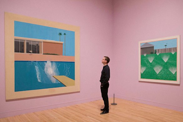 A viewer stands between Hockney’s A Bigger Splash (left) and A Lawn Being Sprinkled.