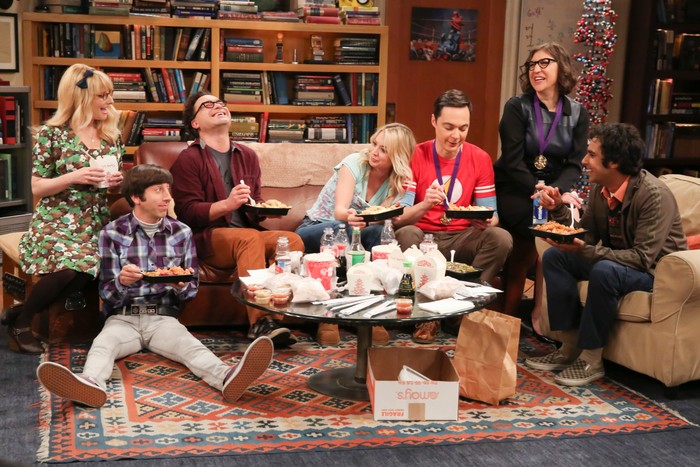 big-bang-theory-finale The main characters in The Big Bang Theory sitting and laughing in the show's living room set, eating takeout food.