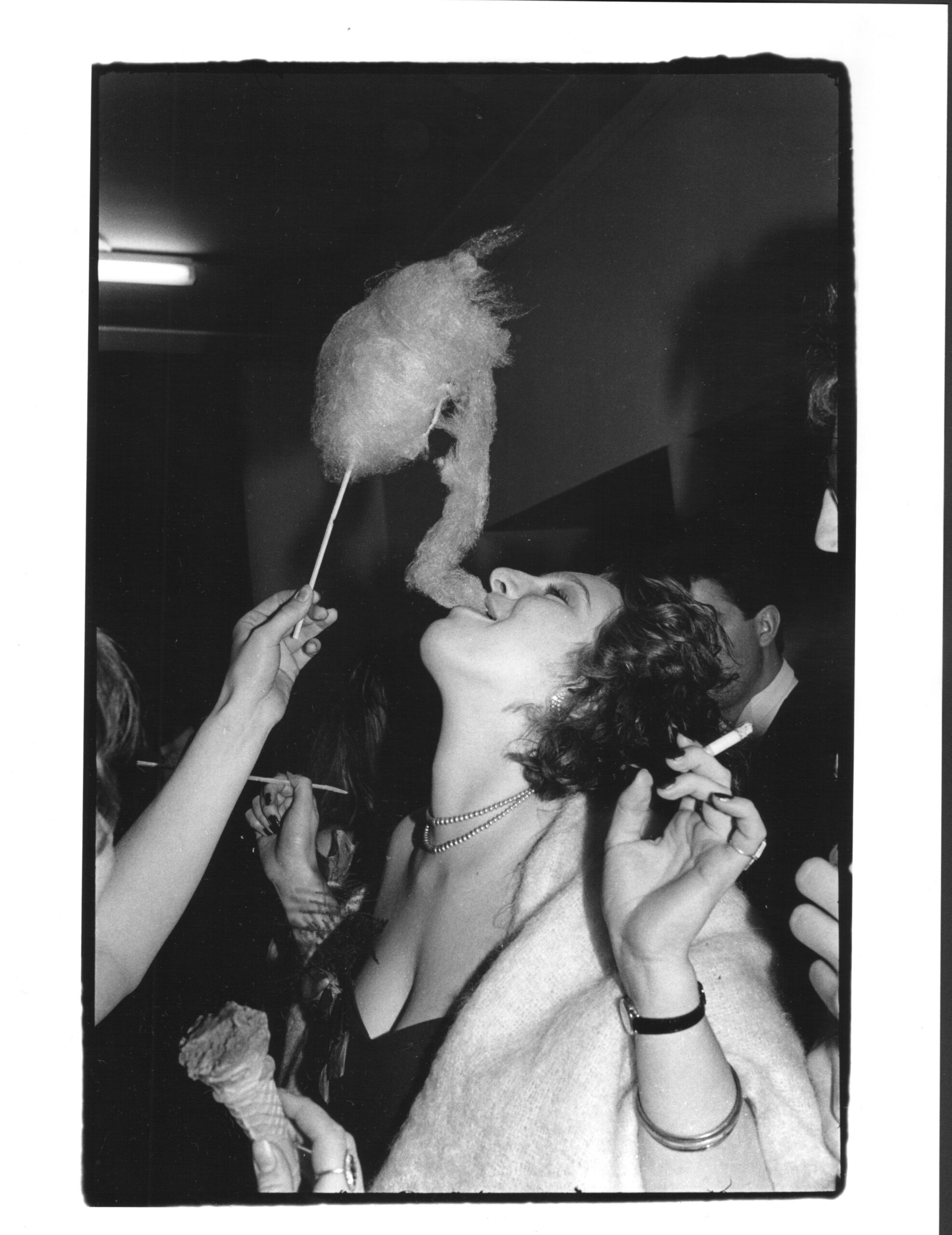 Elizabeth Pulford getting fed cotton candy as she holds a cigarette at Cambridge May Ball