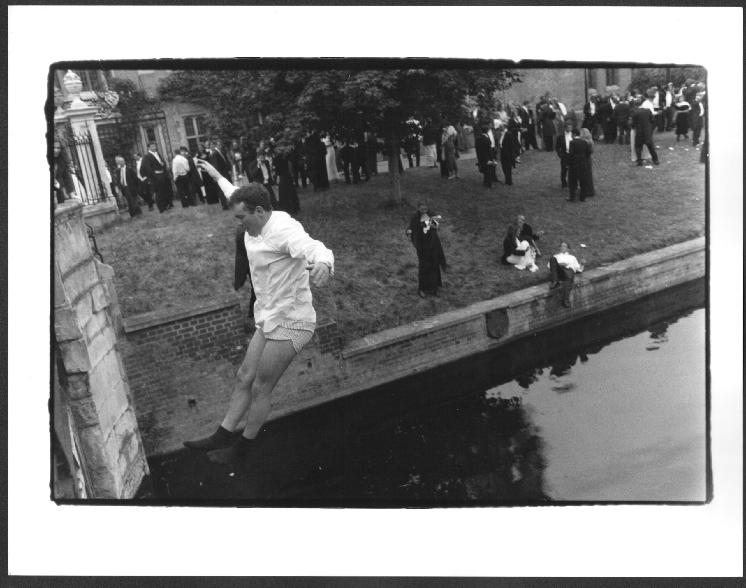 Man jumping into river off bridge at Cambridge May Ball