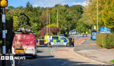 Scene of the crash in Chilwell Lane, Bramcote, Nottinghamshire, with police vehicles and officers and a cordon in place.