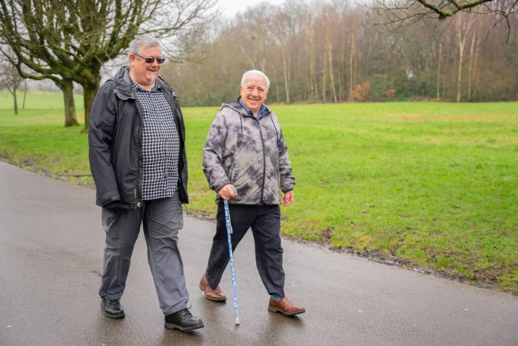 two elderly men walking in the park