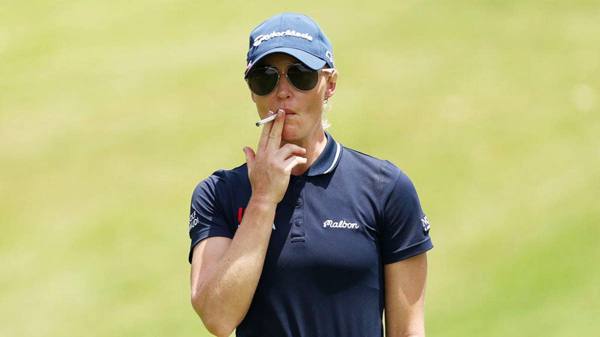 Charley Hull of England smokes while waiting on the 18th hole during the HSBC Women's World Championship.