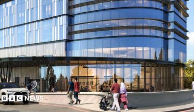 An artists impression of a new hospital building, with a car parked outside, several people walking past. There is a small brick wall outside, a glass, curved building, with lots of glass windows, and a path going round the building.