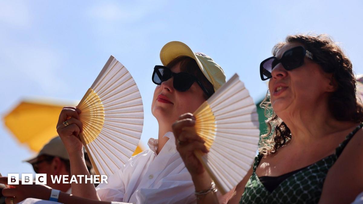 Two women in sunglasses fan themselves, with blue sky and sunshine overhead