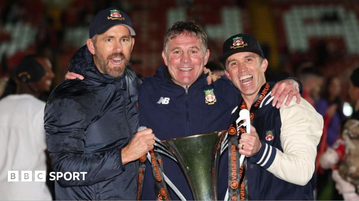 Ryan Reynolds, Phil Parkinson and Rob Mac pose with the National League trophy