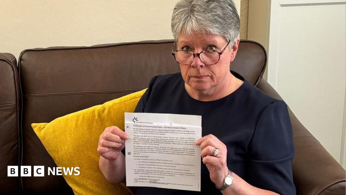 Alison Williams, a woman in her mid-60s with short, grey hair, holding a letter from the Civil Service Pensions Scheme informing her of delays to pension payments.