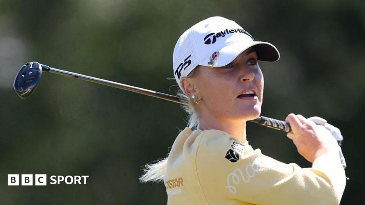 Charley Hull, wearing a yellow top and white cap, with her golf club over her back left shoulder in her follow through