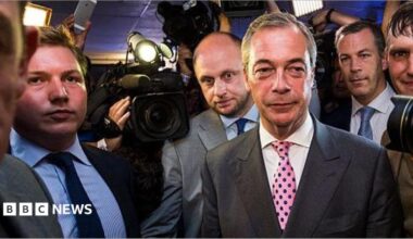 Nigel Farage arrives at the Leave.EU campaign's referendum party in 2016. To his far-right is George Cottrell wearing a light blue shirt and navy tie.