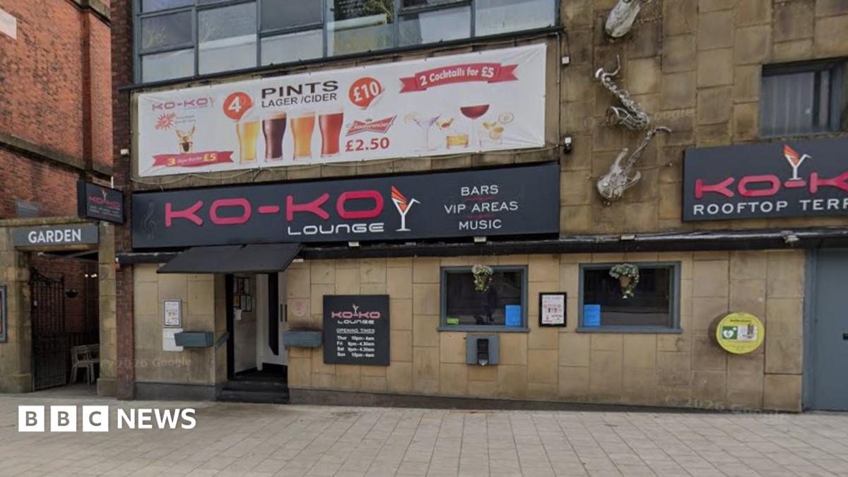 Street view image of the Ko-Ko Lounge, a stone building with two small square windows to the right of the entrance which is under a black canopy and a bright pink on black sign saying Ko-Ko Lounge