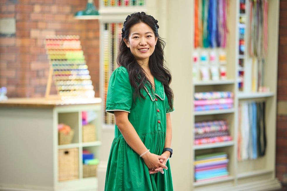 Minnie contestant The Great British Sewing Bee S12 2026 minnie contestant the great british sewing bee s12 2026 in the studio in a green dress