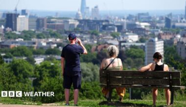 People enjoy the view from Hampstead Heath in London in heatwave conditions in July