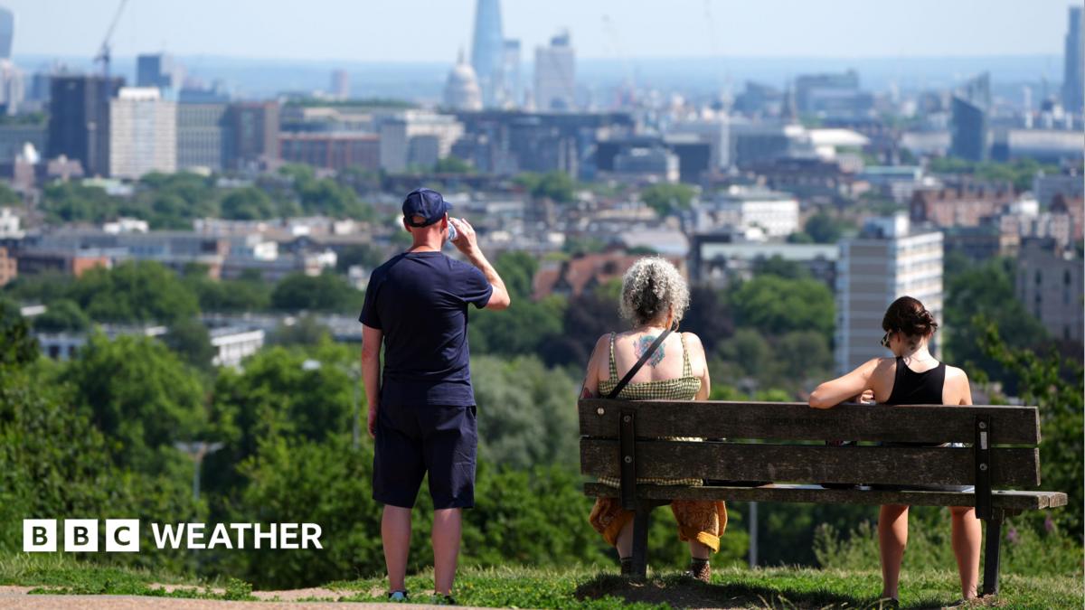 People enjoy the view from Hampstead Heath in London in heatwave conditions in July