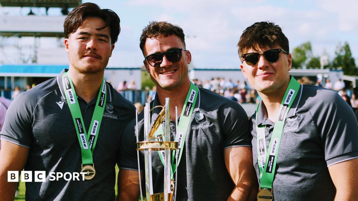 Three Worcester Warriors players celebrate winning the Champ Rugby title with the middle player Will Trewin holding the trophy