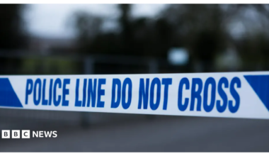 Police tape in white and blue reading "police line do not cross"