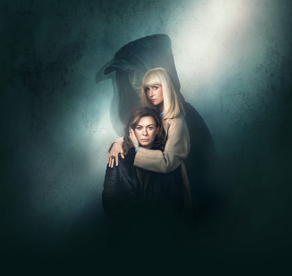 two women embracing with a shadowy hooded figure in the background. two women embracing with a shadowy hooded figure in the background.