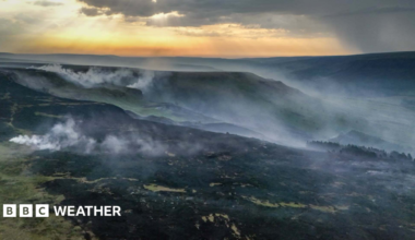 Smoke rises from a large area of scorched ground following a wildfire in Glossop, Derbyshire on June 25