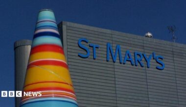 A colourful cone sculpture stands next to the grey facade of St Mary's Hospital.