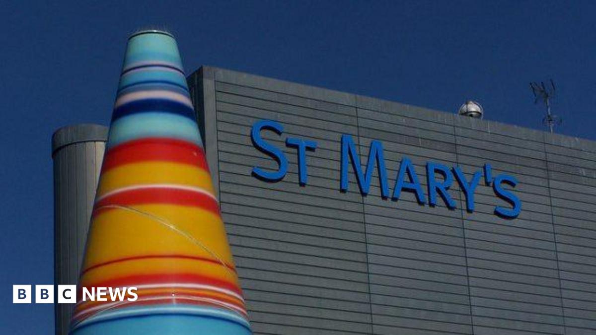 A colourful cone sculpture stands next to the grey facade of St Mary's Hospital.