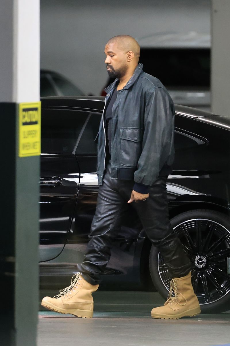 Kanye West stayed true to his signature monochromatic aesthetic in an oversized black leather jacket, black pants and tan boots.