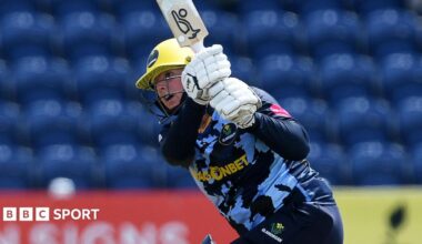 Lauren Parfitt in blue Glamorgan kit and wearing a helmet swings the bat