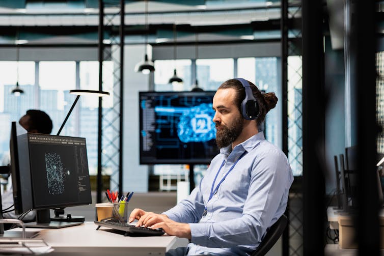 A man works at a computer in an office.