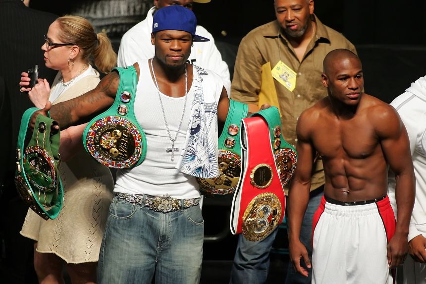 50 Cent, at the height of his rapping career in 2007, holding up Floyd Mayweather Jr.'s belts at the boxer's weight-in ahead of a fight in Las Vegas with Oscar De La Hoya.