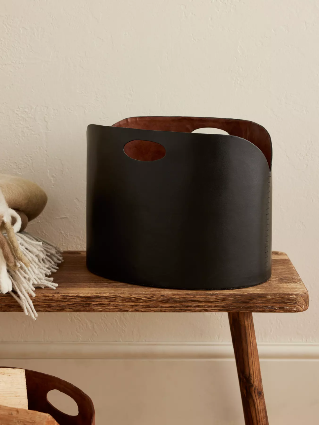 A black faux leather log bucket from Anthropologie
