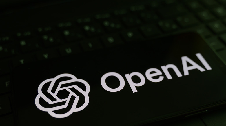 OpenAI logo next to a backlit keyboard.