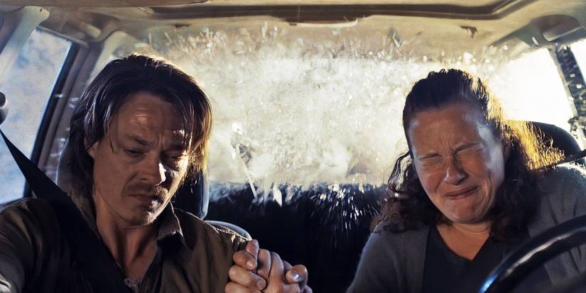 Kristian and Anna hold hands as water crashes into the car they are sitting in in The Wave