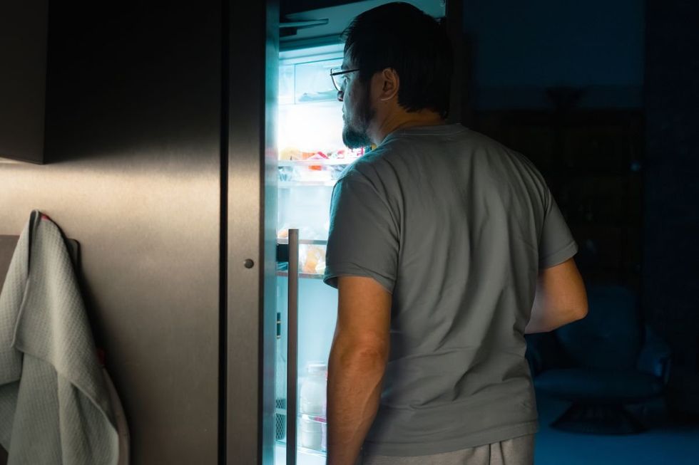 MAN CHECKING FRIDGE