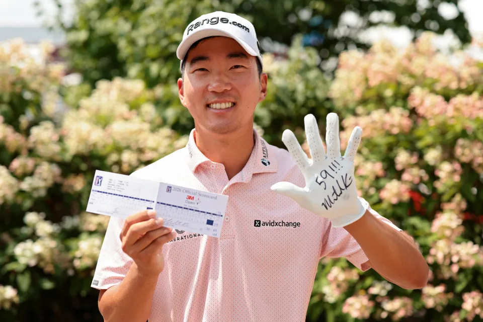 Michael Kim of the United States poses for photos with his scorecard after shooting a 59 during the second round of the 3M Open