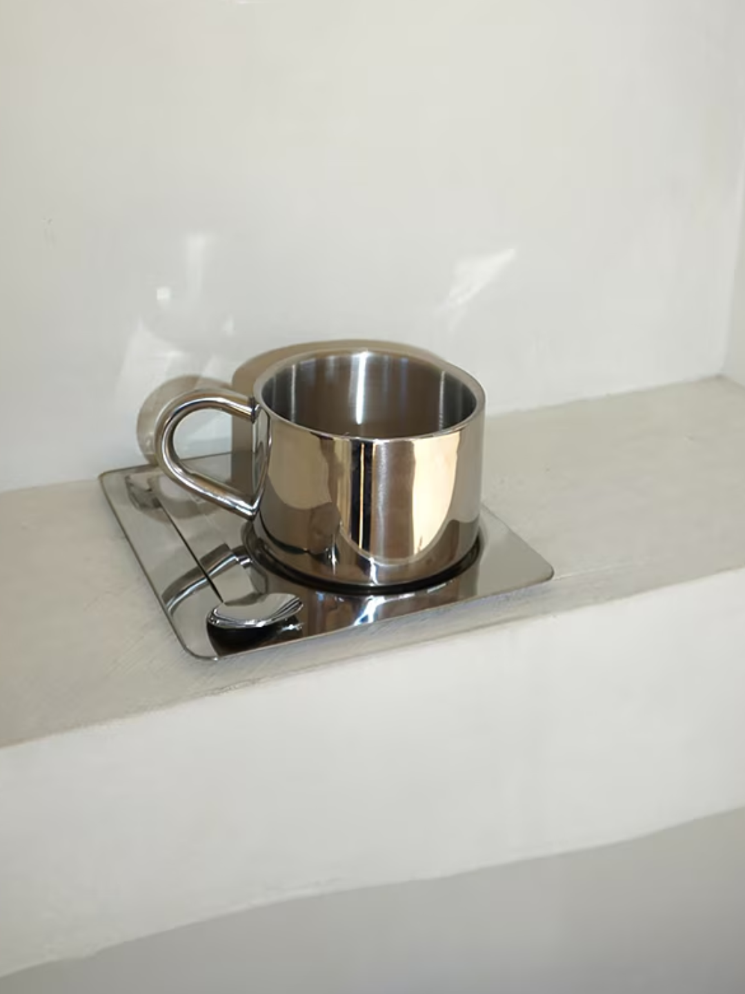 A chrome mug, spoon, and coaster set from HueGah Home