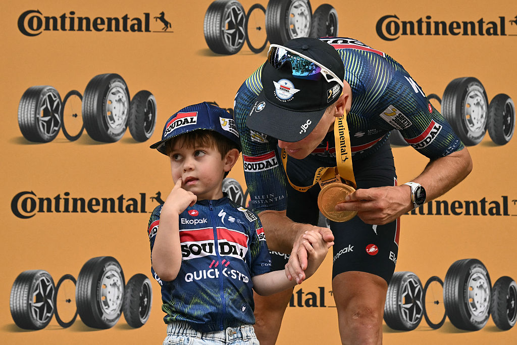 Soudal Quick-Step team's Belgian rider Tim Merlier celebrates on the podium with his son Jules after winning the 12th stage of the 113th edition of the Tour de France cycling race, 179,1 km between Circuit de Nevers Magny-Cours and Chalon-sur-Sa&ocirc;ne in central France, on July 16, 2026. (Photo by Jeff PACHOUD / AFP)