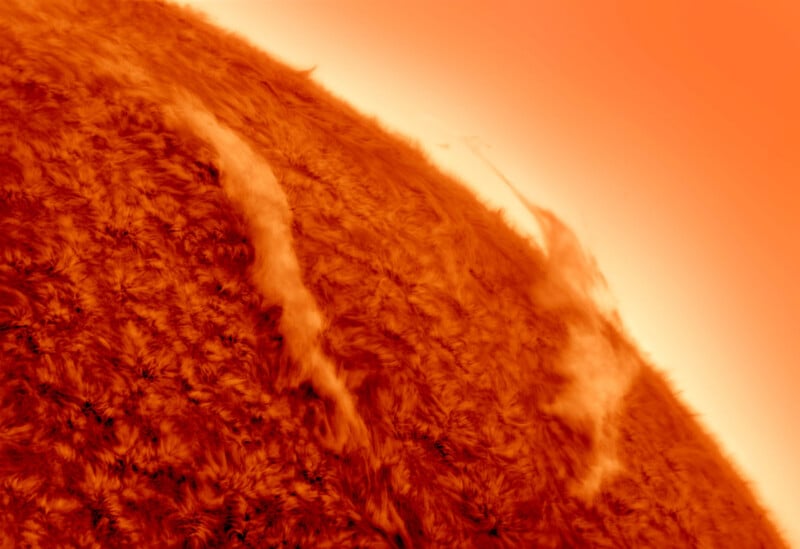 Close-up view of the surface of the Sun, showing swirling patterns and solar prominences with a bright orange-red glow fading to lighter shades at the edge.