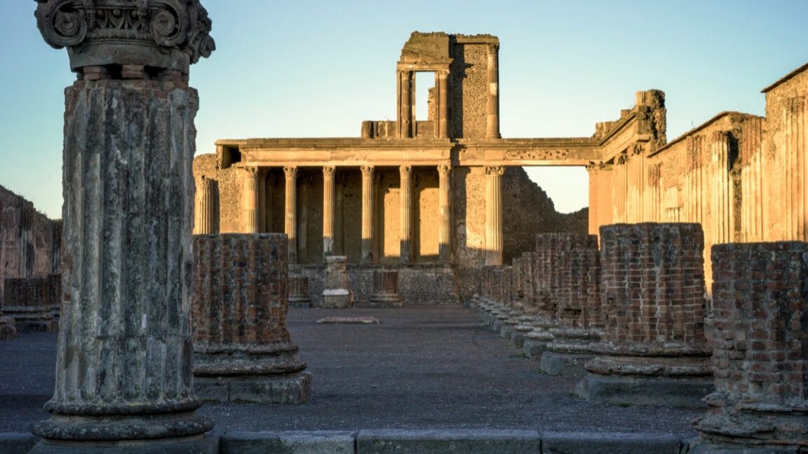 The sun rises over colonnade ruins at Pompeii