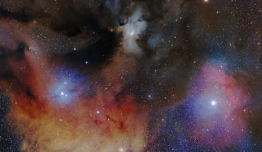 A handful of different types of clouds splatter across the image, with bright stars embedded within. Dust blocks some parts of the clouds. Many small stars cover the background, with a cluster of them sitting in the bottom right beneath all the clouds.